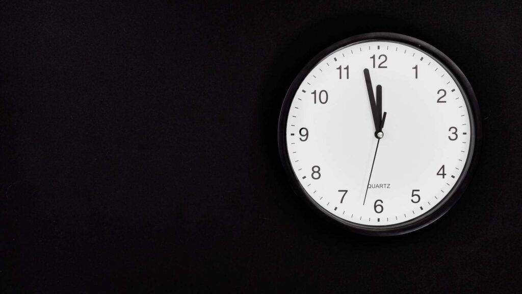 White clock on black background. Photo by Karolina Grabowska from Pexels